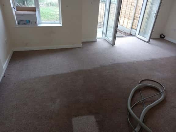 This is a photo of an empty living room with a brown carpet that is in the process of having its carpets steam cleaned works carried out by Clerkenwell Carpet Cleaning