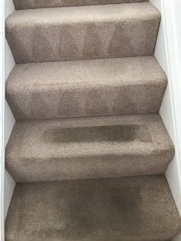 this is a photo of a staircase with beige carpets that is in the process of being cleaned works carried out by Clerkenwell Carpet Cleaning