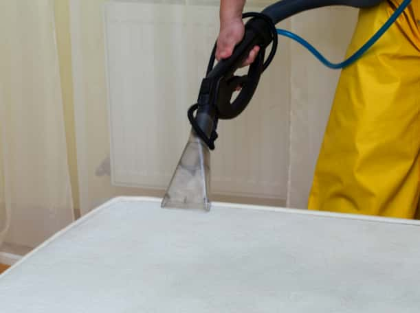 This is a photo of a man steam cleaning a dirty mattress works carried out by Clerkenwell Carpet Cleaning