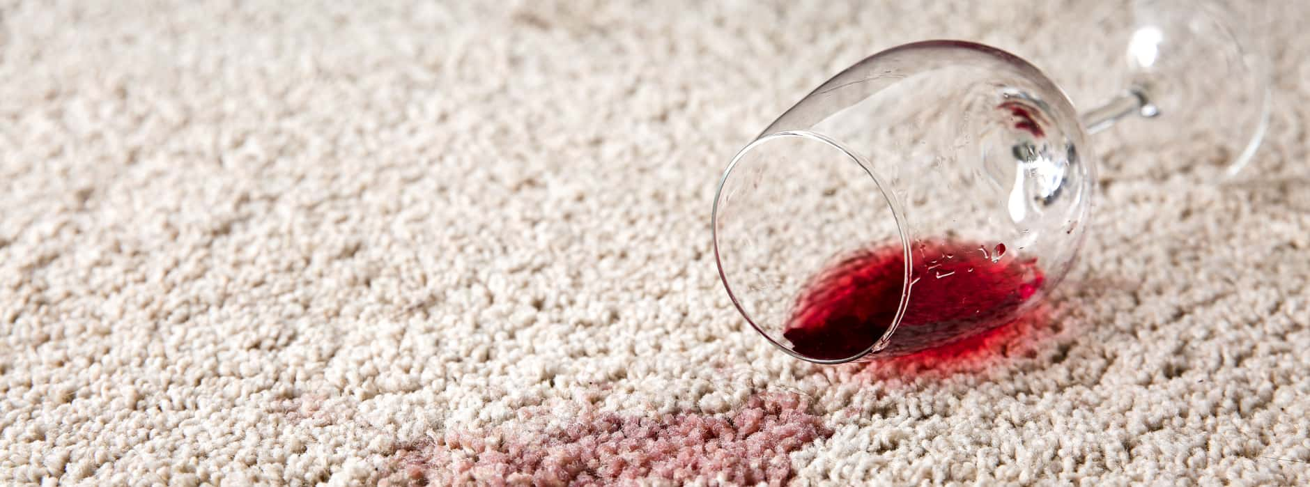 This is a photo of Clerkenwell Carpet Cleaning red wine which has been spilt on a cream carpet. The glass is on its side.